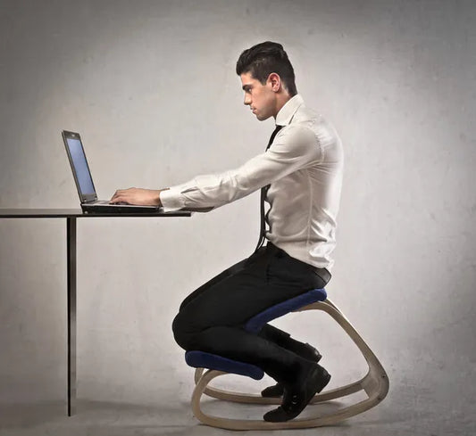 Professional man using an ergonomic kneeling chair at his office workspace, demonstrating optimal posture support, as outlined in the 2024 buyer’s guide for kneeling chairs.