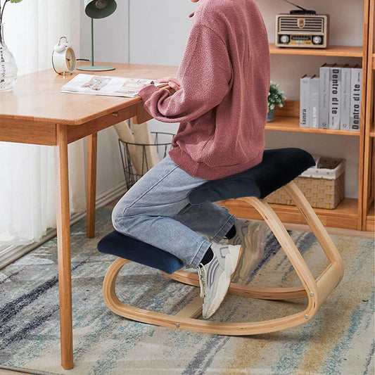 Woman working from home on a modern kneeling chair at her desk, illustrating the trend of kneeling into comfort and health for enhanced ergonomic seating