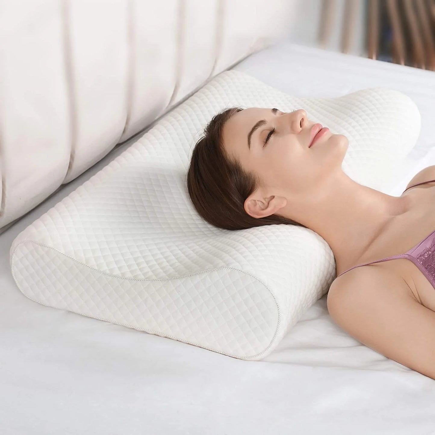 Person resting peacefully on a white memory foam cervical pillow